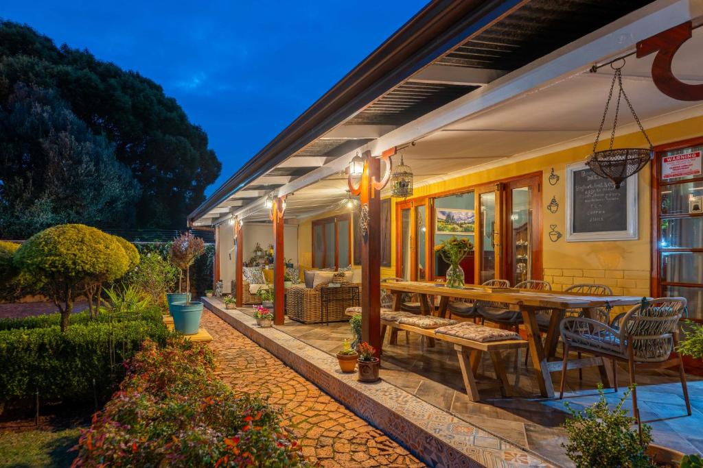 an outdoor patio with a wooden table and chairs at Hampton House Guest House in Centurion