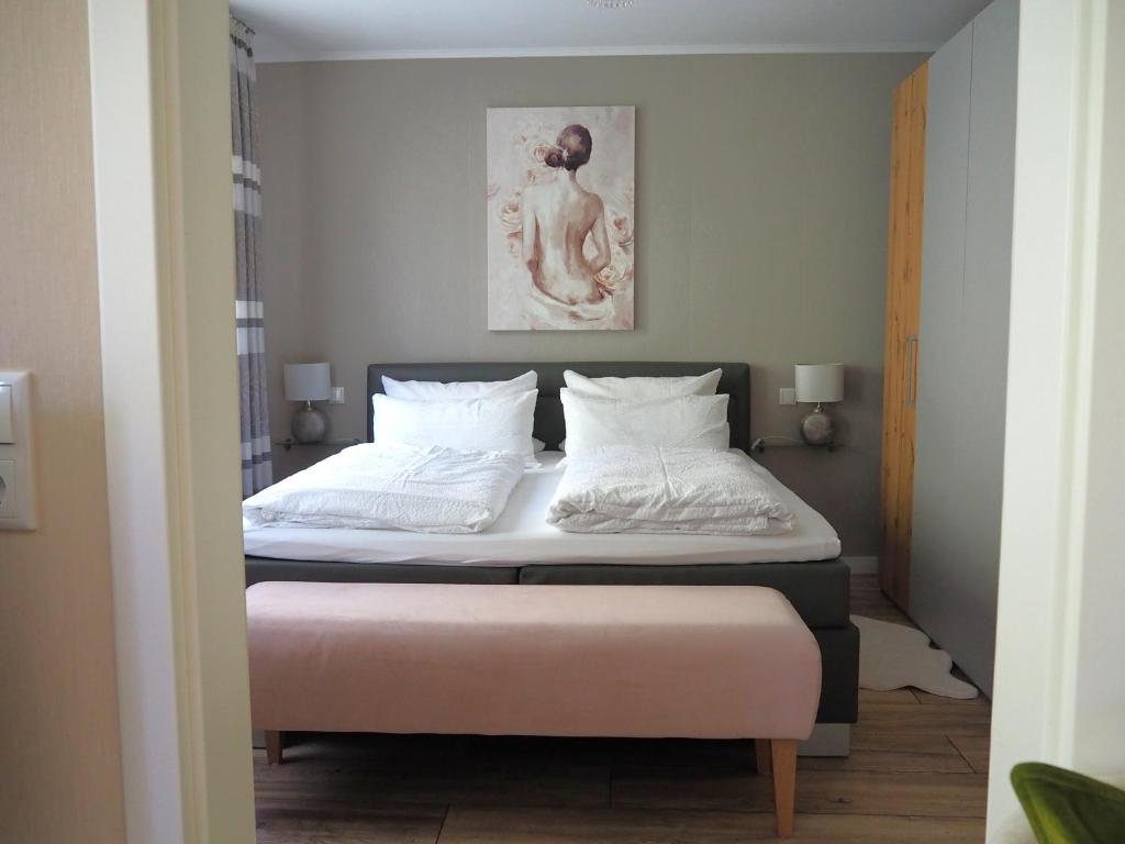 a bedroom with a large bed with white sheets at Apartment Schlossblick - Top location in Idar-Oberstein