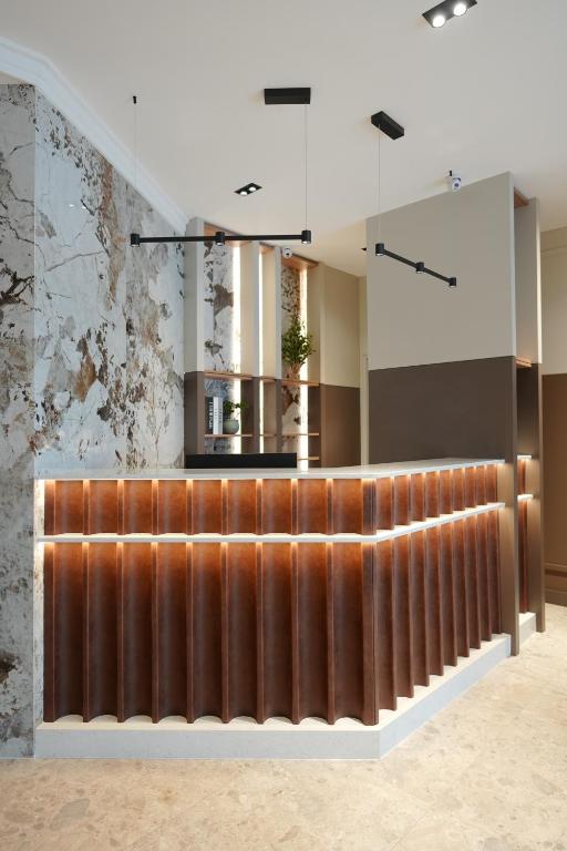 a lobby with a wooden fence and a mirror at Hotel Botika in Kraljevo
