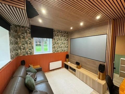 a living room with a couch and a large screen at Séjour Château Moderne avec Cinéma in Verberie