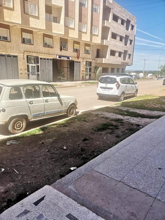 two cars parked in a parking lot in front of a building at Zerarda in Saïss