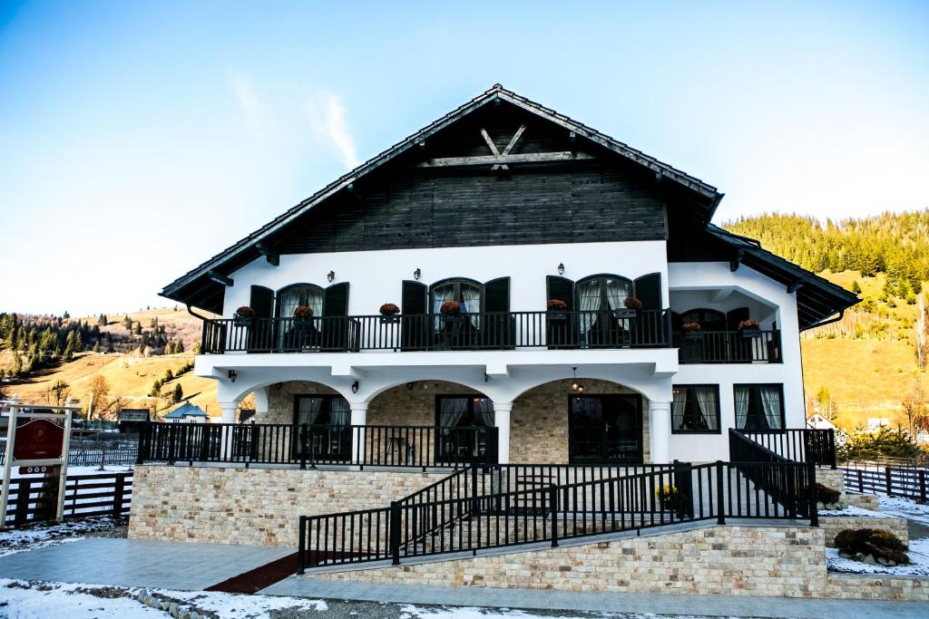 a house with a balcony with people on it at Luisenthal Conac in Fundu Moldovei