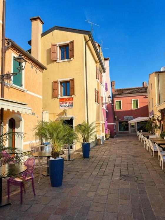 a courtyard with tables and chairs and a building at La Casa del Mare in Caorle