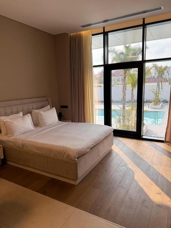 a bedroom with a large bed and a large window at Sea Breeze Lighthouse in Nardaran