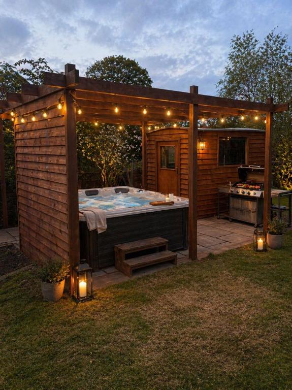 a large hot tub in a backyard with lights at Lilac Cottage in Barnard Castle