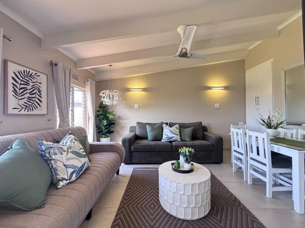 a living room with a couch and a table at Chakas Rock Ocean View Bliss Ballito in Ballito