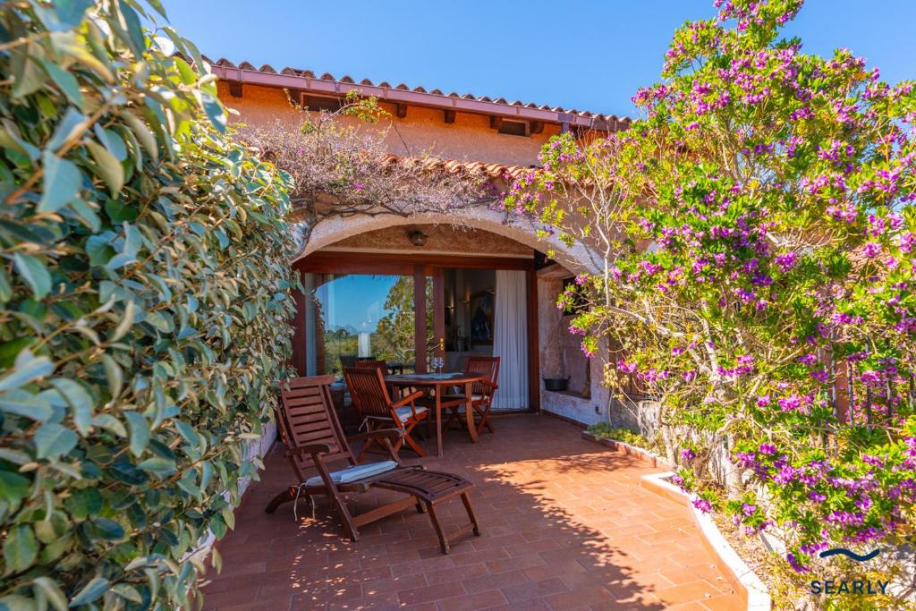 a patio with a table and chairs and flowers at Casa Corallina in Olbia