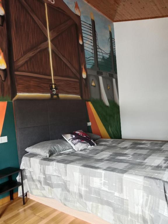 a bed in a room with a painting on the wall at Apartamento Jurásico in Barreiros