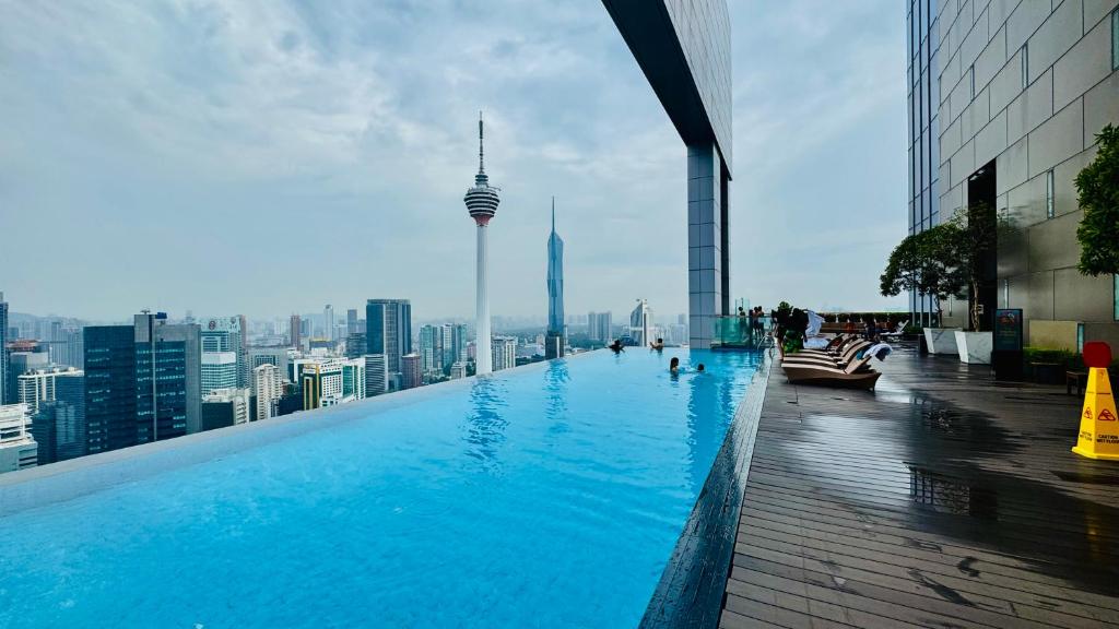 a swimming pool on top of a building with a view of the city at Platinum Astern SUITES by KLCC in Kuala Lumpur