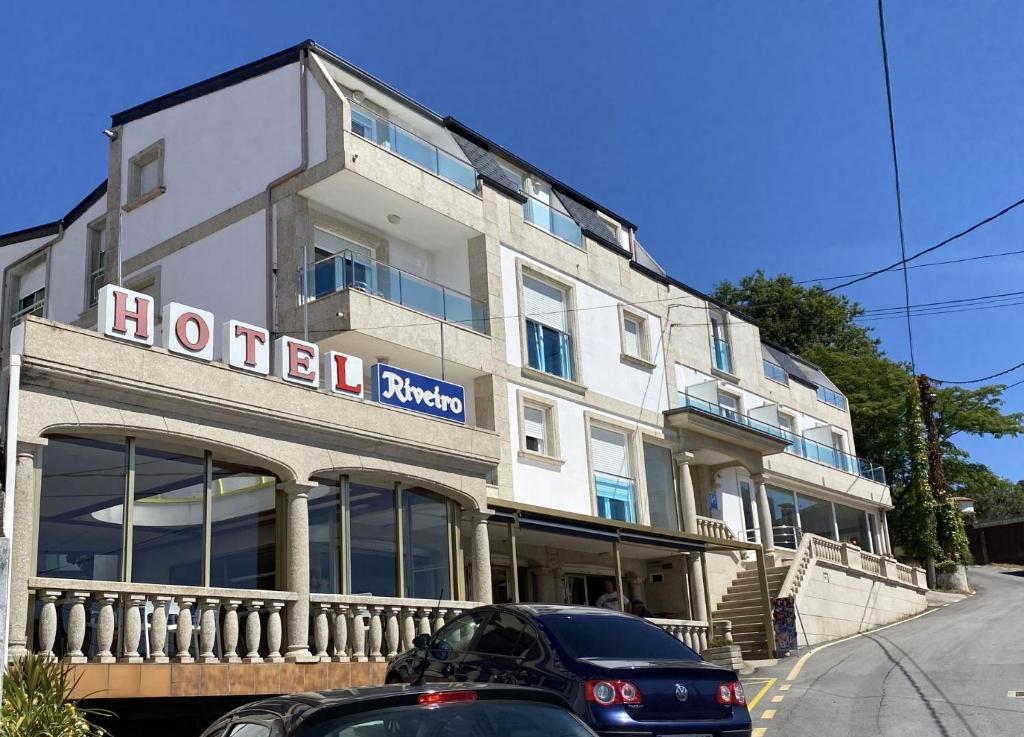 a hotel building with a sign on the side of it at Hotel Riveiro in Sanxenxo