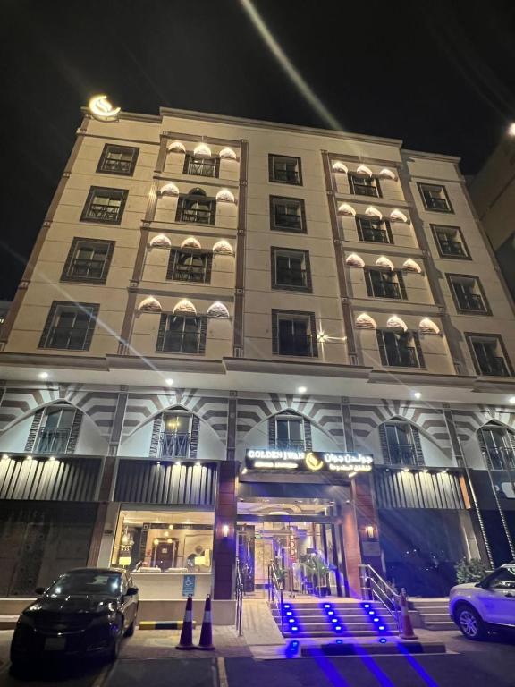 a large building with cars parked in front of it at شقق جوان الذهبية الاولى للشقق المخدومة اقتصادية in Jeddah