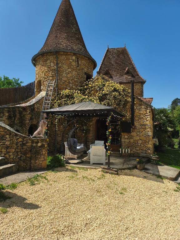 a stone building with a gazebo in the yard at Chambre de la Tour 1 in Milhac
