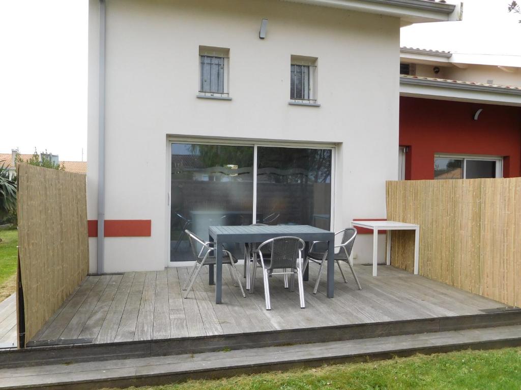 a patio with a table and chairs in front of a house at Villa Soulacaise V in Soulac-sur-Mer