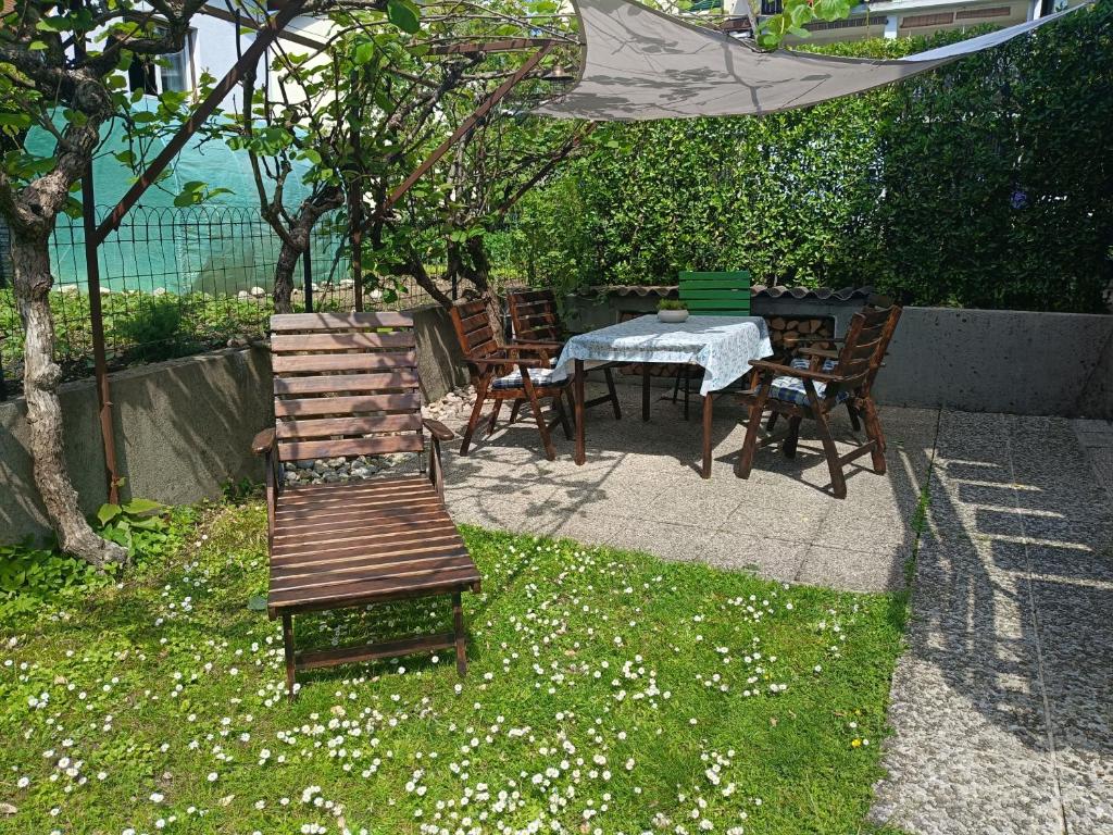 a table and chairs and a wooden bench in a yard at Gravitacija West in Tolmin