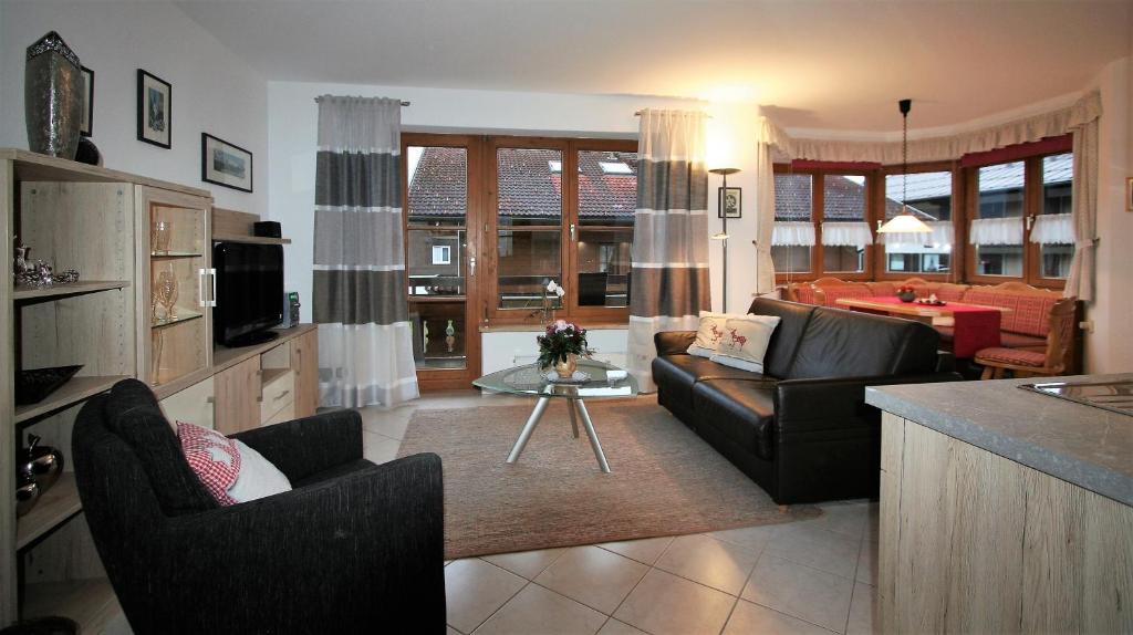 een woonkamer met banken en een tafel in een kamer bij Alpenflair Ferienwohnungen Whg 201 "Doris" in Oberstdorf