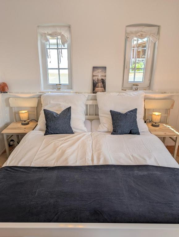 a large white bed with two blue pillows on it at Ferienwohnung Natursjæl in Tielen