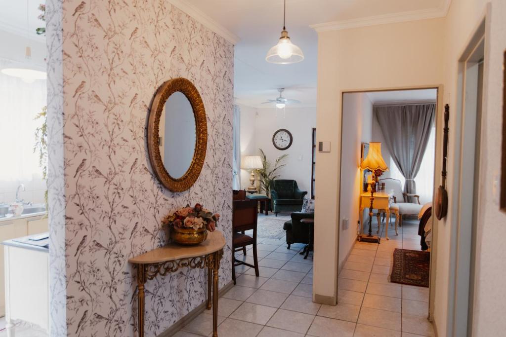 a living room with a mirror on a wall at The Hidden Garden Guesthouse in Meyerton