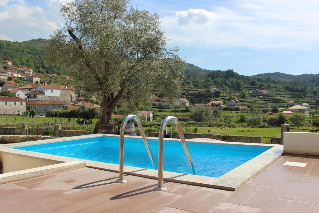a swimming pool with two metal railings in front of a house at Recanto da Malhadoira in Currais
