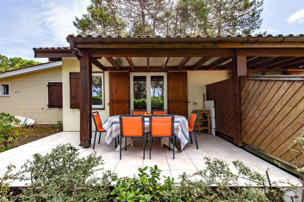 a patio with a table and chairs on it at Lacanau Océan avec jardin in Lacanau-Océan