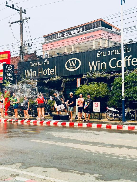 a group of people standing on the side of a street at Win Hotel Vang Vieng in Vang Vieng