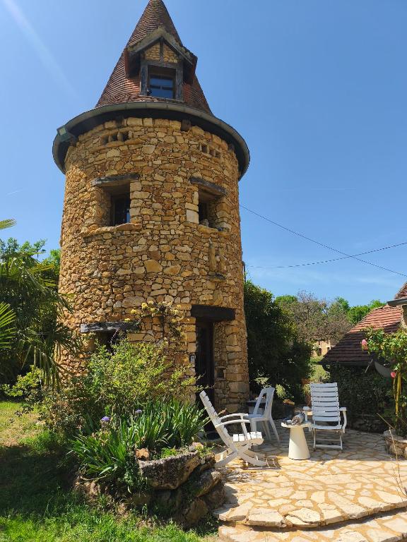 a brick tower with a window and two chairs at Chambre de la Tour 2 in Milhac