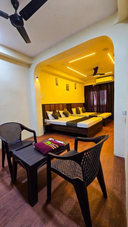 a bedroom with a bed and a table and chairs at Shivalay Premium Homestay in Ujjain