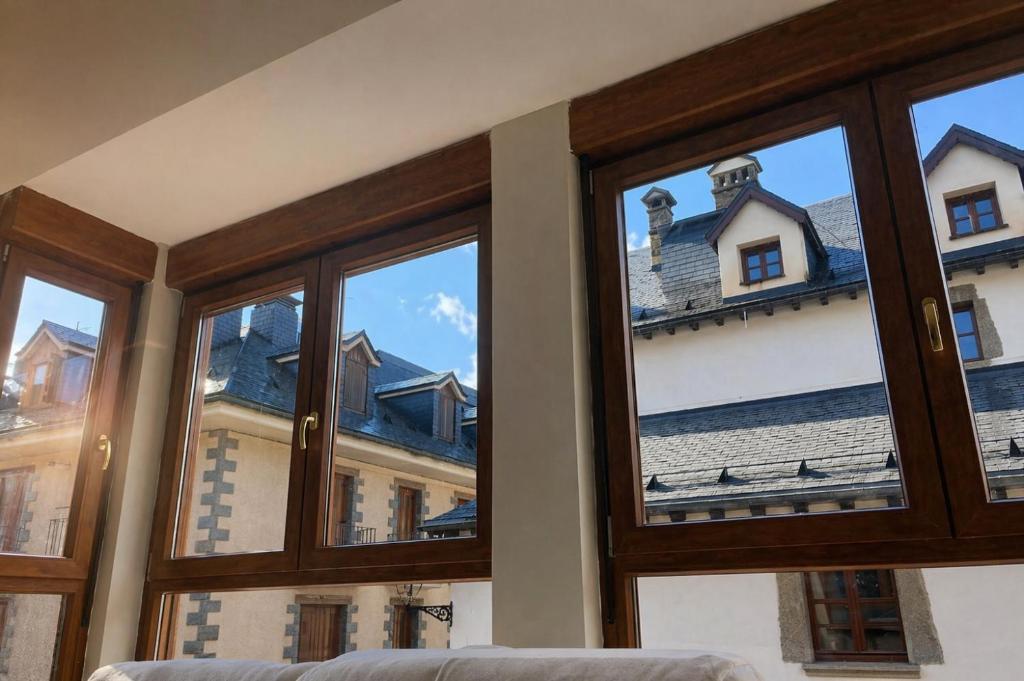 a room with windows looking out at a house at Biescas Suites in Biescas