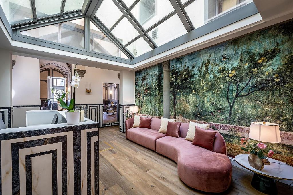 a living room with a pink couch and a large painting at Gold Artè Collection in Florence