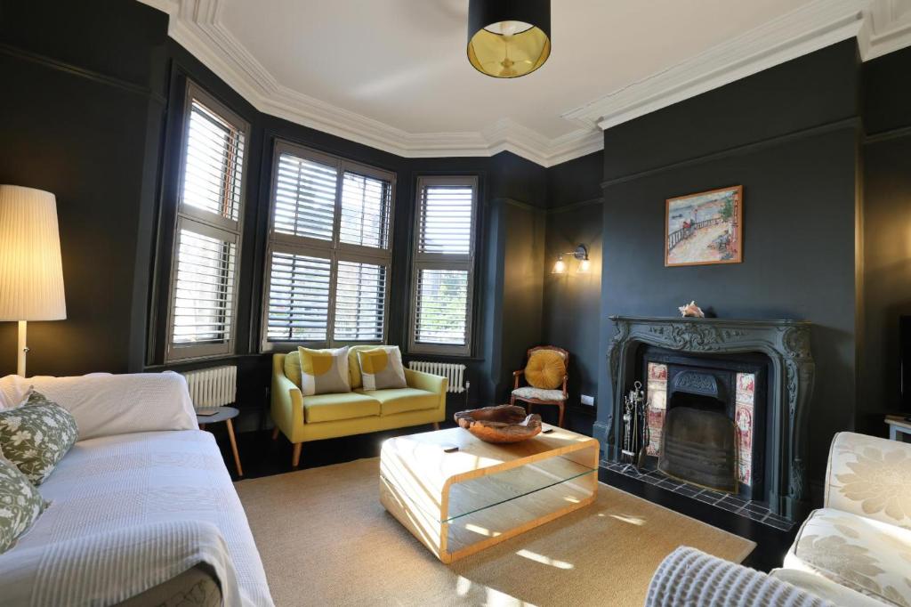 a living room with a couch and a fireplace at Suffolk Coast Townhouse in Pakefield