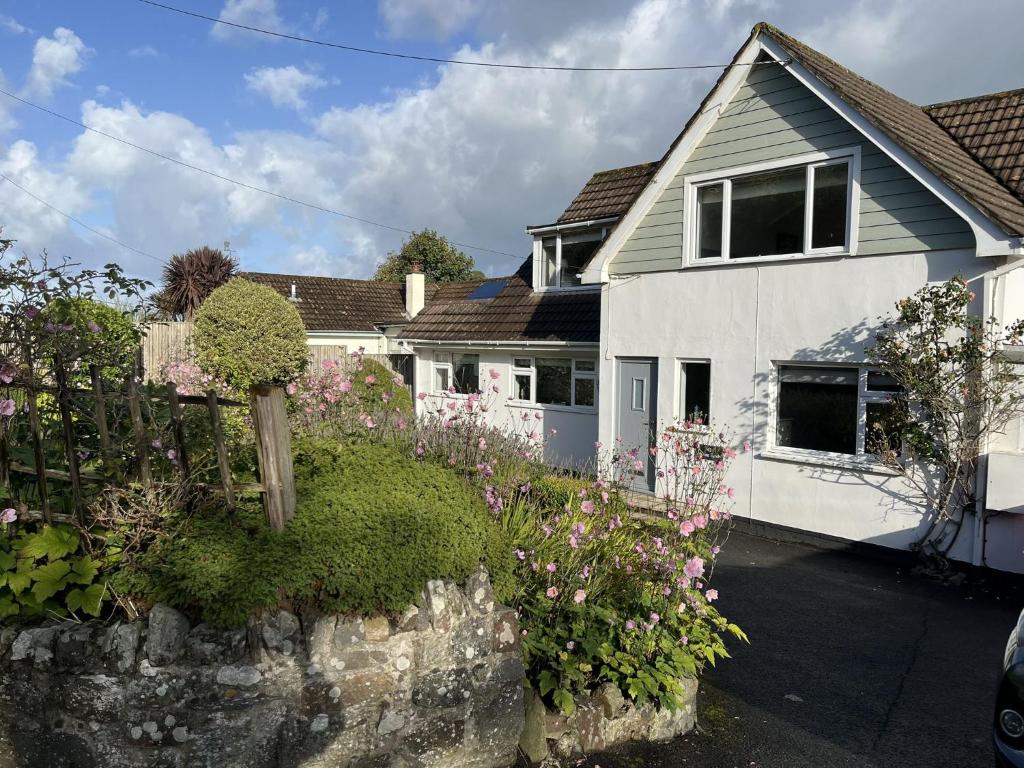 a white house with a bunch of flowers in front of it at White Sands in Croyde