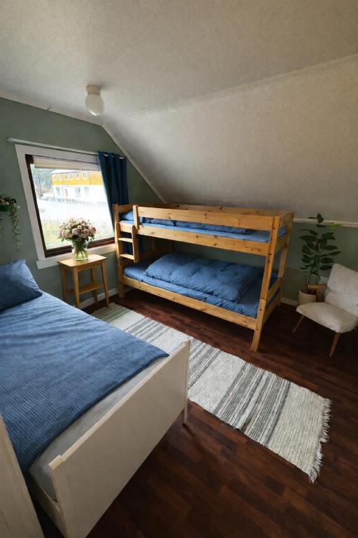 a bedroom with a bunk bed and a chair at Alfa Room - The LOWFO House Lofoten in Moskenes