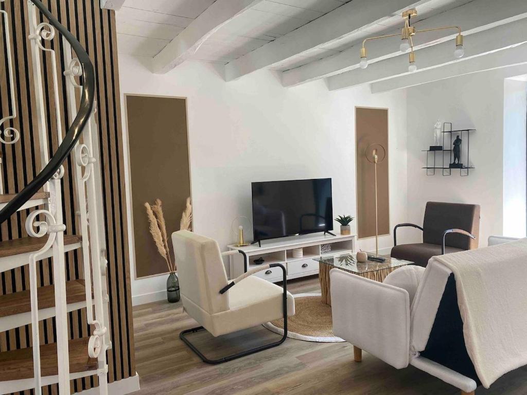 a living room with white furniture and a flat screen tv at La Stracciatella Saint-Aignan in Saint-Aignan