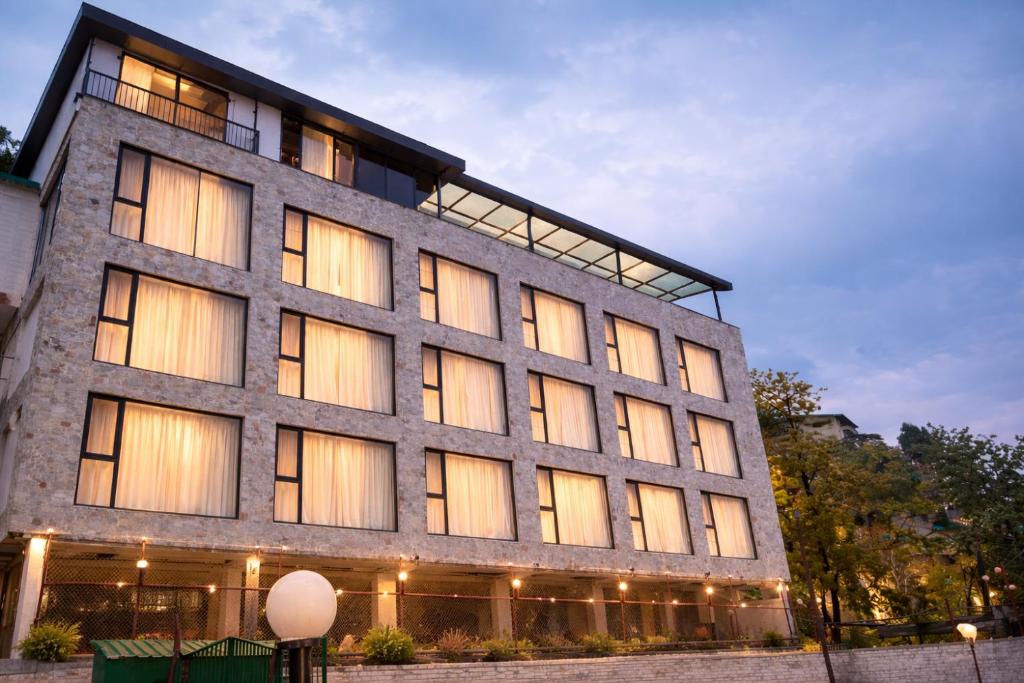 a large stone building with many windows at AB's Abode-A Boutique Hotel in Mussoorie