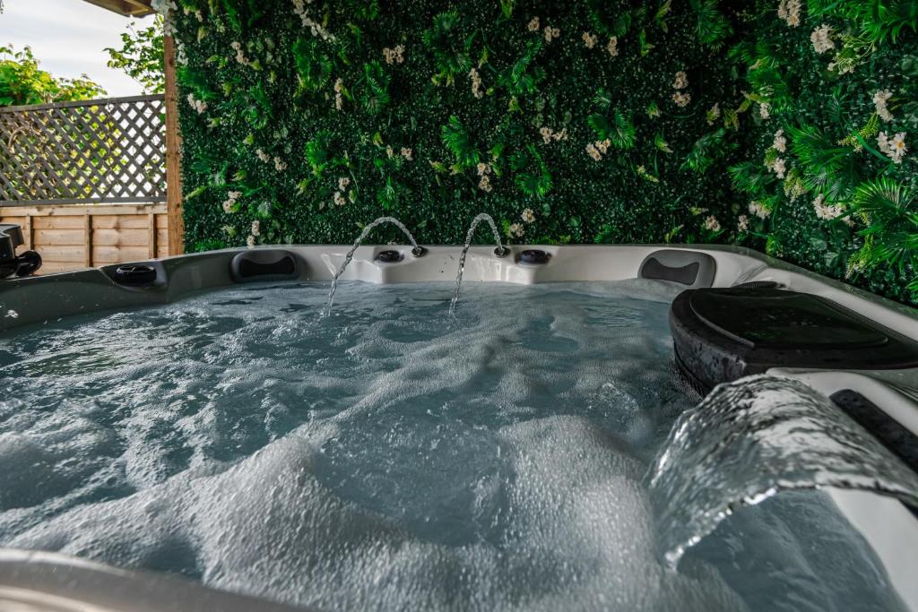 a hot tub with water and a tire in it at Sun Set House With Hot Tub in Witchford