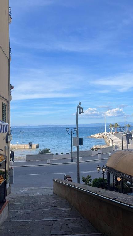 an empty street next to a beach with a street light at Casa Per 4 in Porto Santo Stefano