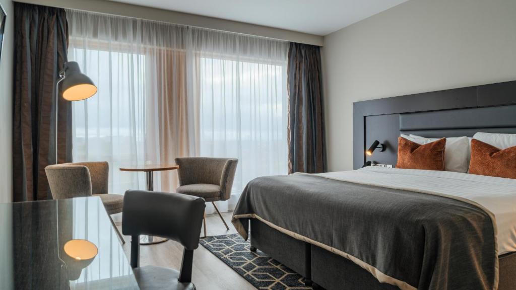 a hotel room with a bed and a table and chairs at Athlone Springs Hotel in Athlone