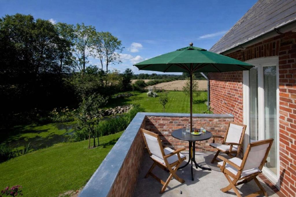 a patio with a table and chairs and an umbrella at Lake View - Flensburger Förde in Westerholz