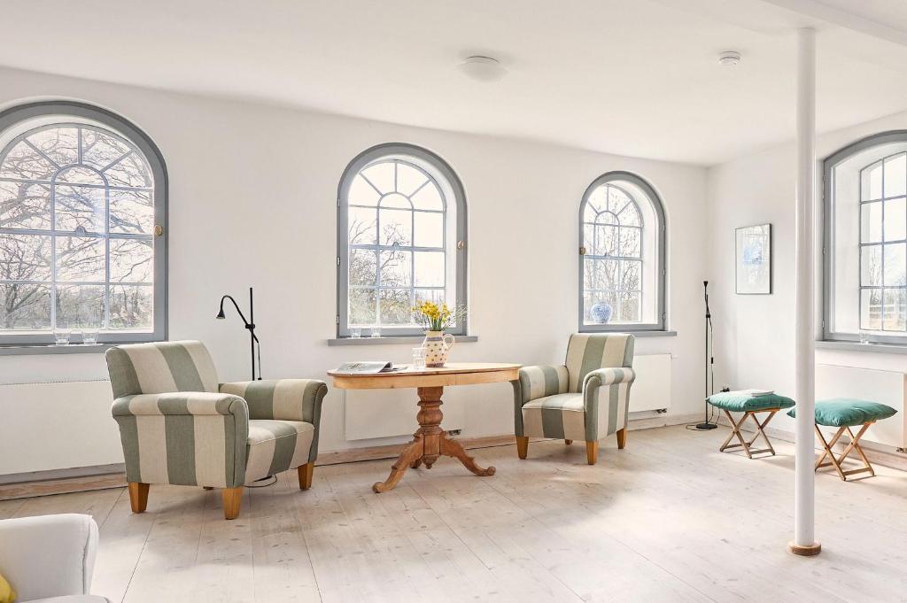 a room with a table and chairs and windows at Rose Garden - Flensburger Förde in Westerholz