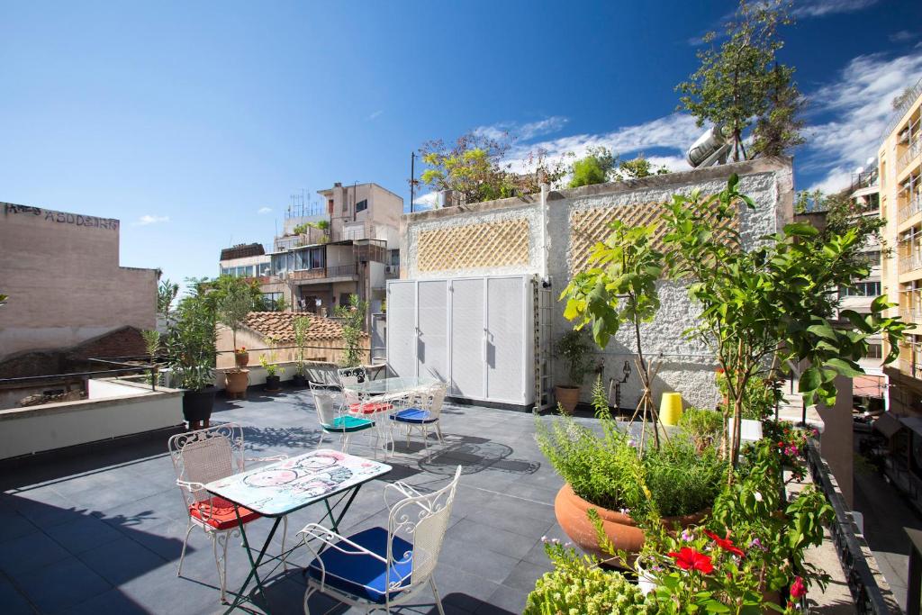 patio z krzesłami i stołem na balkonie w obiekcie Lovely, central, private balconies, roof garden! - EP7 w Atenach