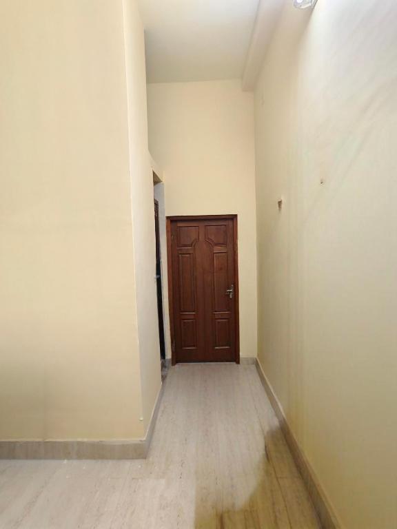 an empty room with a door and a wooden floor at Swapnanir in Howrah