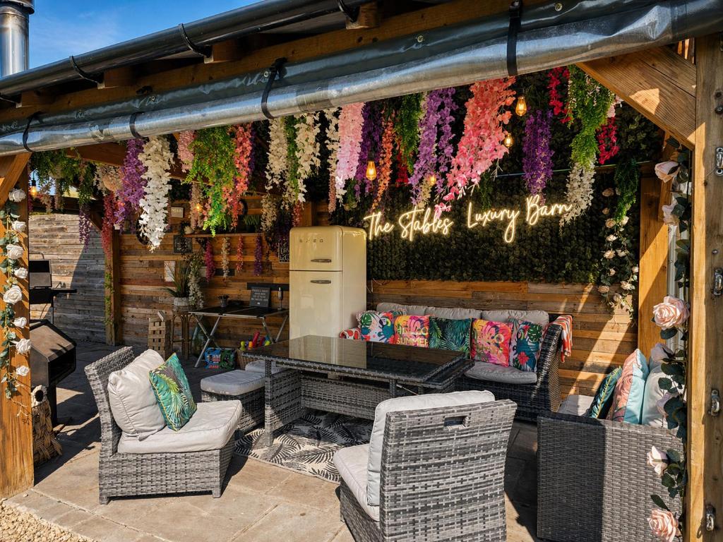 a store with a table and chairs and flowers at The Stables Luxury House with Hot tub in York
