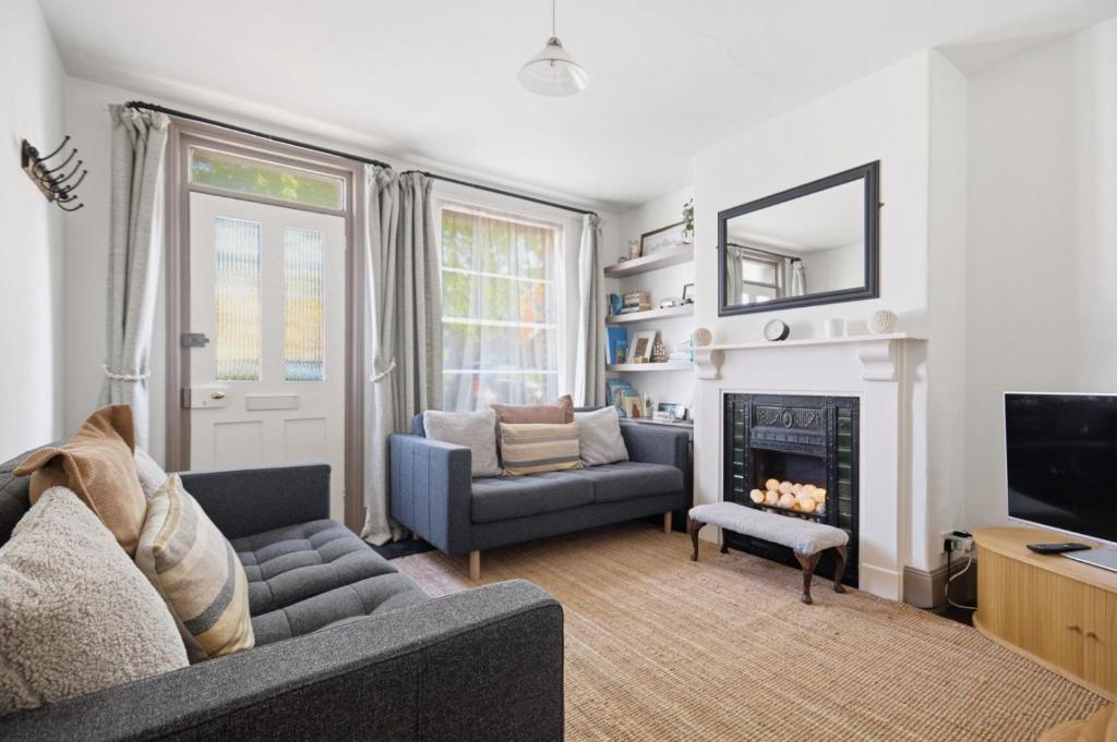 a living room with a couch and a fireplace at Coastguards in Southwold
