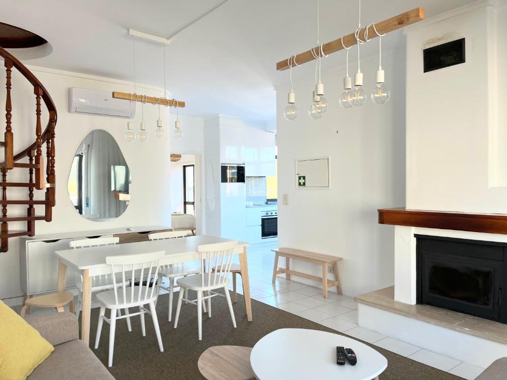 a living room with a table and chairs and a fireplace at Salt Beach Apartments B in Viana do Castelo