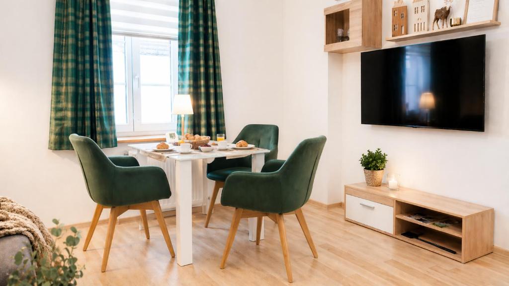 a living room with a table and four chairs at Ruhige Ferienwohnung am Fürst-Pückler-Park, Sauna im Haus & Parkplatz Bad Muskau in Bad Muskau