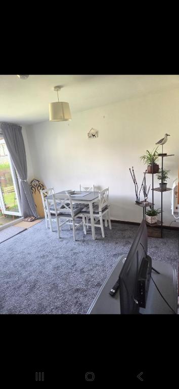a dining room with a white table and chairs at 49 Strawberry Hill in Hayle