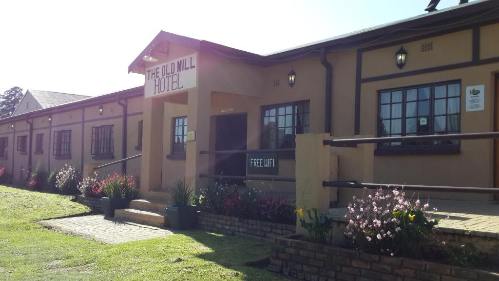 un edificio con flores delante en The Old Mill Hotel, en Machadodorp