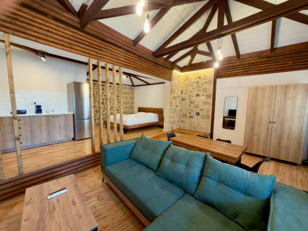 a living room with a blue couch and a bedroom at Eleon apartments in Kalamata