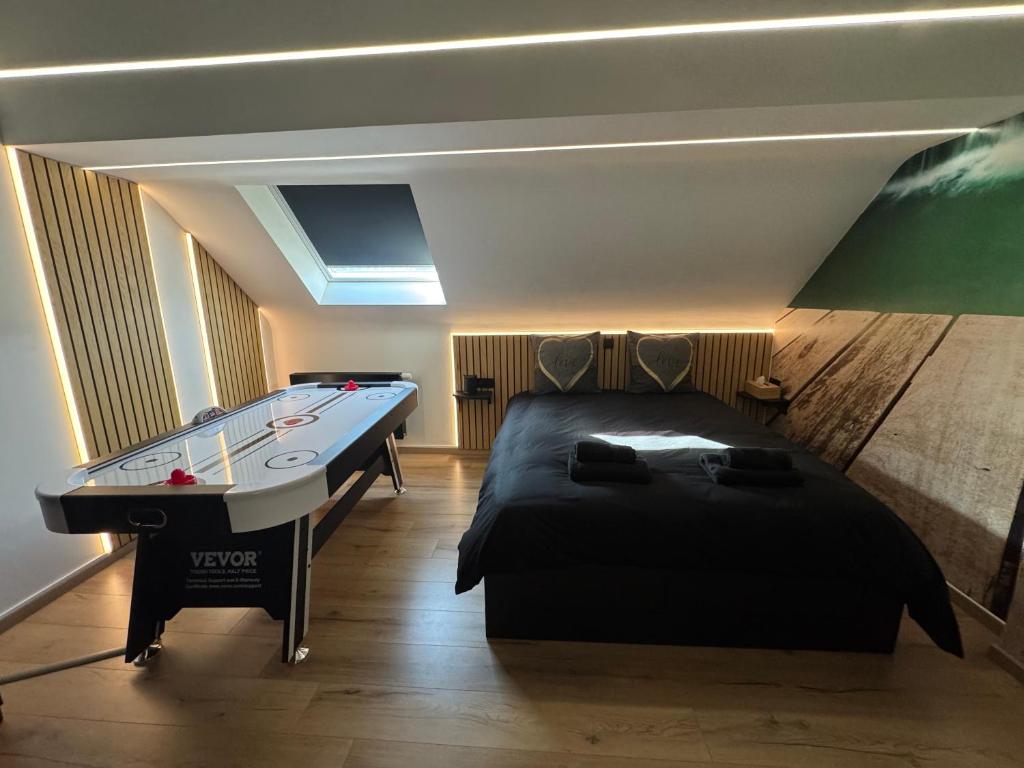 a room with a bed and a pool table at Studio détente, sdb privative, billard, air soccer, clim in Verviers