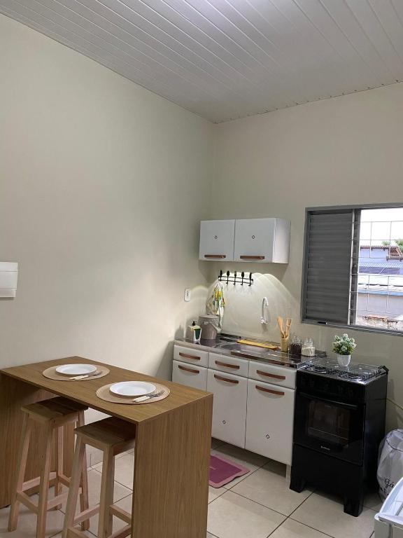 a kitchen with a table and a stove top oven at Aconchego da Si AP in Nova Mutum