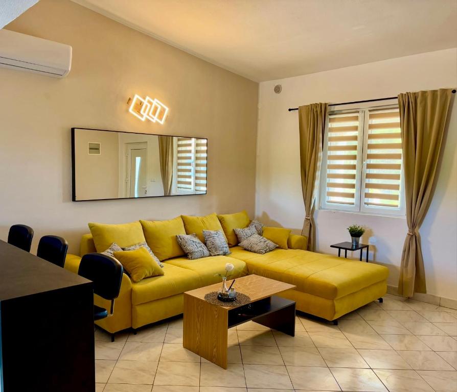 a yellow couch in a living room with a mirror at Amore in Vir
